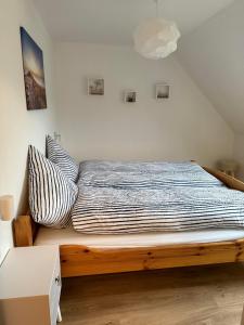 a bed with a wooden frame in a room at Ferienwohnung "Lütt Welt" in Welt
