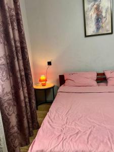 a bedroom with a bed and a table with a lamp at Smart Apartment на Соборной 23 in Kremenchuk