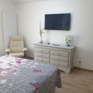 una camera con un letto e un comò con una televisione di Logement indépendant chez l'habitant, situé dans les Pyrénées a Bordères-sur-lʼÉchez