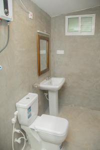a bathroom with a white toilet and a sink at Araliya Villa Hikkaduwa in Hikkaduwa +16 photos