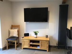 a living room with a tv and a table and a chair at Renovated 2 bed Cottage in Ulverston, Garden with Views in Ulverston