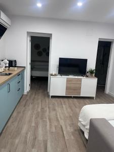 a kitchen with white cabinets and wooden floors in a room at Apartamento Bajo de Guía bajo A in Sanlúcar de Barrameda +6 photos