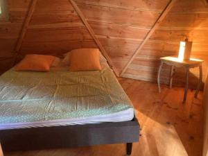 a bed in a wooden room with a candle on a table at Camping 3 étoiles - eed0ca in Priziac