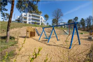 a playground with a blue swing set in a park at FeWo Tommy in Zirchow