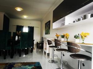 a room with a bar with chairs and a table at Moll & Kie Luxury Accommodation in Burgersfort