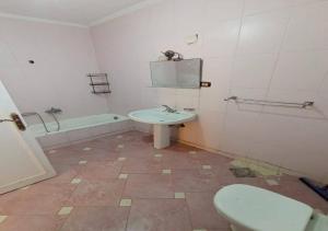 a bathroom with a toilet and a sink and a tub at استمتع بالبحر والمسبح في فيلا راقية بأفضل موقع الساحل الشمالي in Dawwār Ḩalīs +9 photos