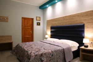 a bedroom with a large bed with a black headboard at Casa Michelangelo in Porto SantʼElpidio