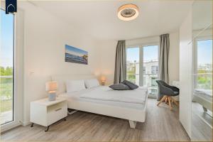une chambre blanche avec un lit et une fenêtre dans l'établissement An der Haffküste FeWo Ankerplatz, à Zirchow