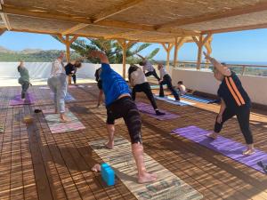 a group of people doing yoga on a roof at Infinity Wellness Boutique Hotel in Afráta