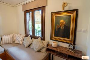 a living room with a couch and a painting on the wall at Ines Elysium in Kastoria