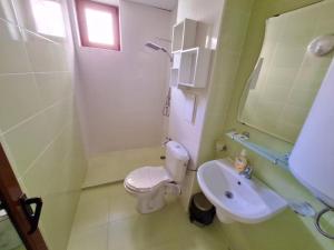 a bathroom with a white toilet and a sink at Stamopolu Apartments in Primorsko
