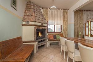a dining room with a fireplace and a table and chairs at Guesthouse Green Istria in Truške