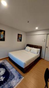 a bedroom with a large bed with white sheets at The Minimalist Stay Station 18 in Ipoh