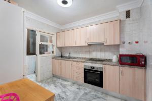 a kitchen with wooden cabinets and a red microwave at Al Mar Los Gigantes in Puerto de Santiago +22 photos