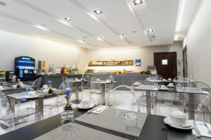 バルセロナにあるIkonik Ramblasのテーブルと椅子が備わるレストラン