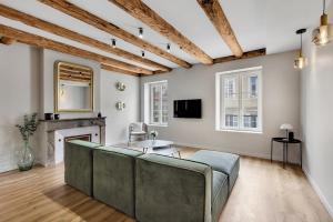 una sala de estar con un sofá y una chimenea en Le Gambetta - Élégance et Confort - Vue sur la Place Stanislas, en Nancy