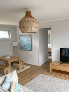 a living room with a couch and a table at Seaside Daisy 3 Bedrooms 6 Beds in Goolwa