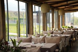 a row of tables in a room with windows at Eco-hotel AQBULAQ in Kaynazarka