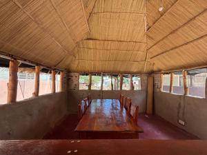 a long wooden table in a building with chairs at Simoonga guest house in Livingstone