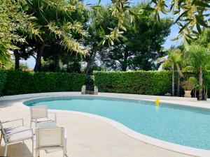 a swimming pool with two chairs and a table and sidx sidx sidx at Il Calesse - Noto in Noto