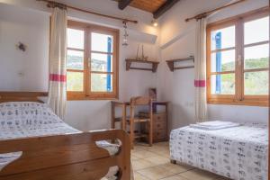 a bedroom with two beds and two windows at Seaside Resort in Kritharia