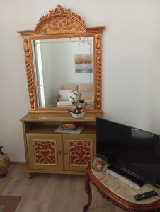 a mirror sitting on top of a dresser with a tv at Corte Maria in Castri di Lecce