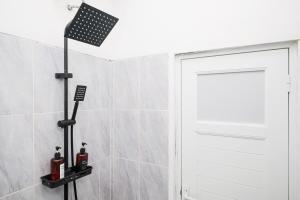 a bathroom with a shower with a white door at RedDoorz near Candi Prambanan 3 Yogyakarta in Kenaran