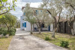 a house with blue windows and a driveway at Seaside Resort in Kritharia