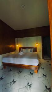 a bedroom with a large bed with a wooden headboard at Poetri bungalow Superior ROOM in Mantaak