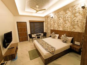 a bedroom with a bed and a table and a television at Hotel Cloud Inn, Nainital in Rāmgarh