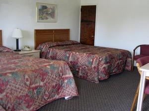 a hotel room with two beds and a lamp at Red Carpet Inn & Suites Morgantown in Morgantown