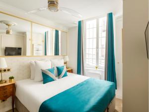 sypialnia z dużym łóżkiem z niebieskimi zasłonami w obiekcie Merveil - Luxury Suite - Marais - Saint Martin I w Paryżu