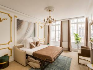 sypialnia z łóżkiem i żyrandolem w obiekcie Merveil - Luxury Suite - Marais - Saint Martin I w Paryżu +27 zdjęć