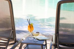 a table with a drink and a laptop on it at Peppers Beach Club in Port Douglas