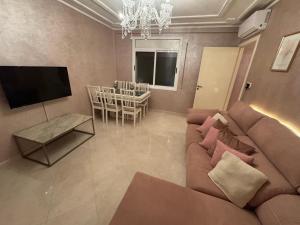 a living room with a couch and a dining room at Appartement Nador in Nador +8 photos