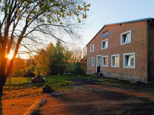 a brick building with the sun setting behind it at ByTheLake in Konstantinovy Lázně