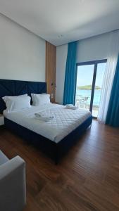a bedroom with a bed with a view of the ocean at King Hotel Ksamil in Ksamil +16 photos