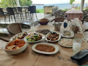a table with many plates of food on it at Aigeiros Apartments & restaurant in Skala Mistegnon