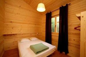 a bedroom with a bed in a wooden room at ZEcamping 3 étoiles animaux acceptés piscine et aire de jeux in Porto-Vecchio