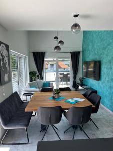 a living room with a wooden table and chairs at LUX PENTHOUSE Klopeiner See Apartment Ferienwohnung FeWo in Sankt Kanzian