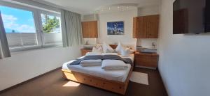 a bedroom with a bed and a large window at Appartements Haus Olympia in Innsbruck