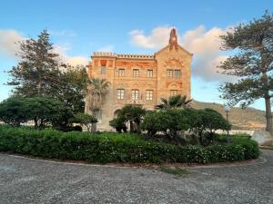a large brick building with trees in front of it at La Casa del Moro in Favignana
