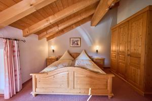 a bedroom with a wooden bed in a room at Ferienhof Almfrieden in Balderschwang
