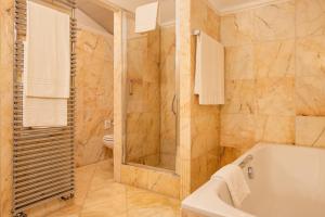 bagno con vasca, doccia e servizi igienici di Hotel De La Paix a Lugano