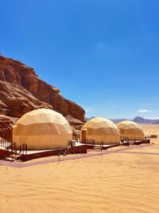 a group of four domes in the desert at Wadi Rum Mars Camp in Wadi Rum