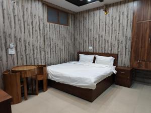 a bedroom with a bed and a table and a bed sidx sidx sidx at Agyatvaas in Bhīm Tāl