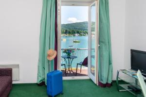 a room with a balcony with a view of a lake at Haus Zinnauer in Velden am Wörthersee