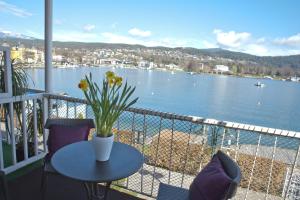 a balcony with a table and a view of the water at Haus Zinnauer in Velden am Wörthersee
