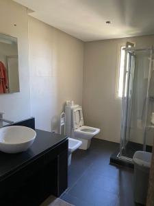a bathroom with a sink and a toilet and a shower at Cozy beach house in Skhirat