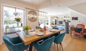 a dining room and living room with a table and chairs at Sonniges modernes ruhiges grosses Haus Garten Pool in Oberhaching